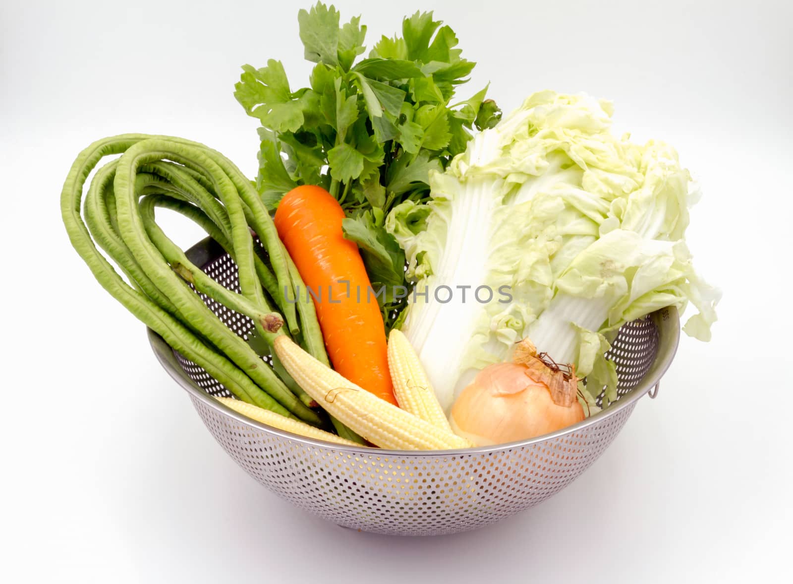 Various types of vegetables in aluminium basket on white background.