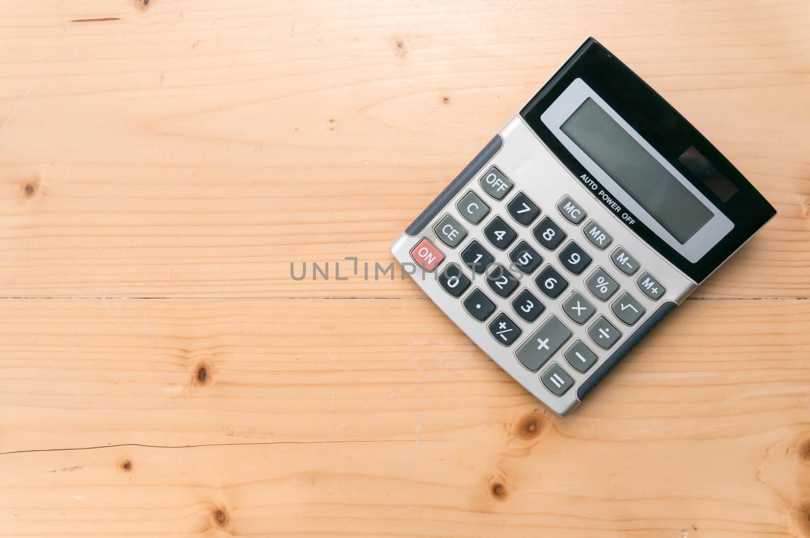 Calculator on wooden table background. free space for text.