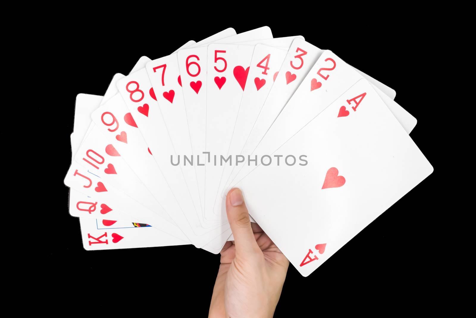 Hand holding Playing cards isolated on black background.