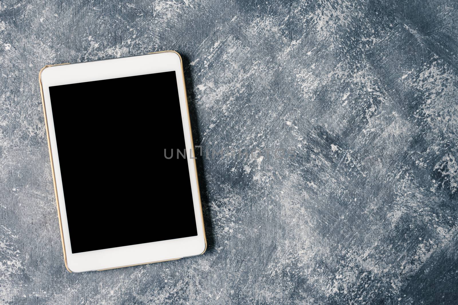 White tablet touch computer gadget with touch blank black screen on grunge background.