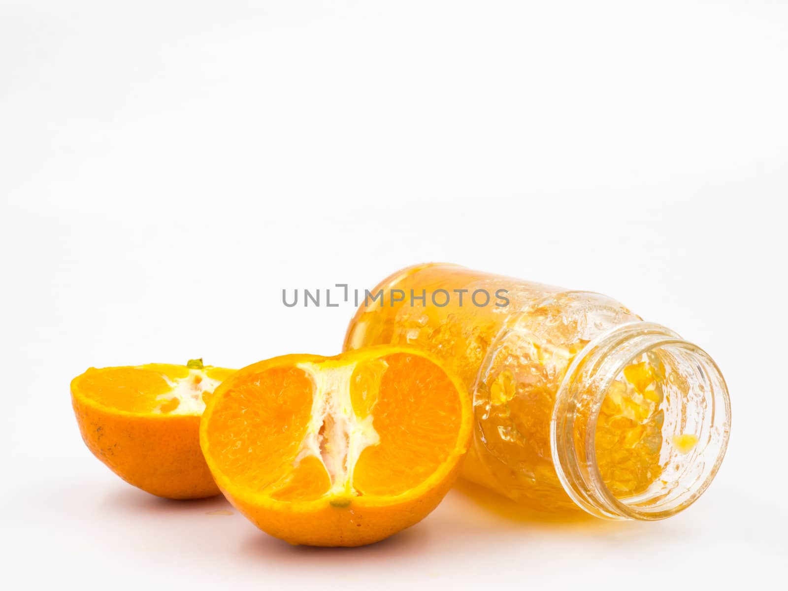 Fresh orange with orange jam in glass jar on white background.