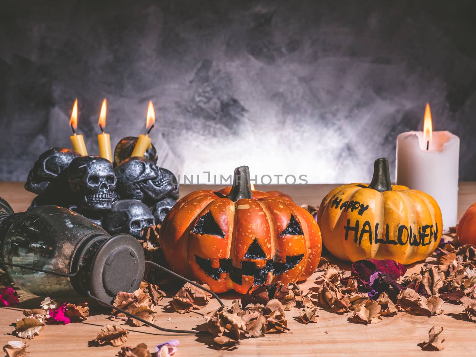Halloween pumpkins with candlelight and skulls on dark background by ronnarong