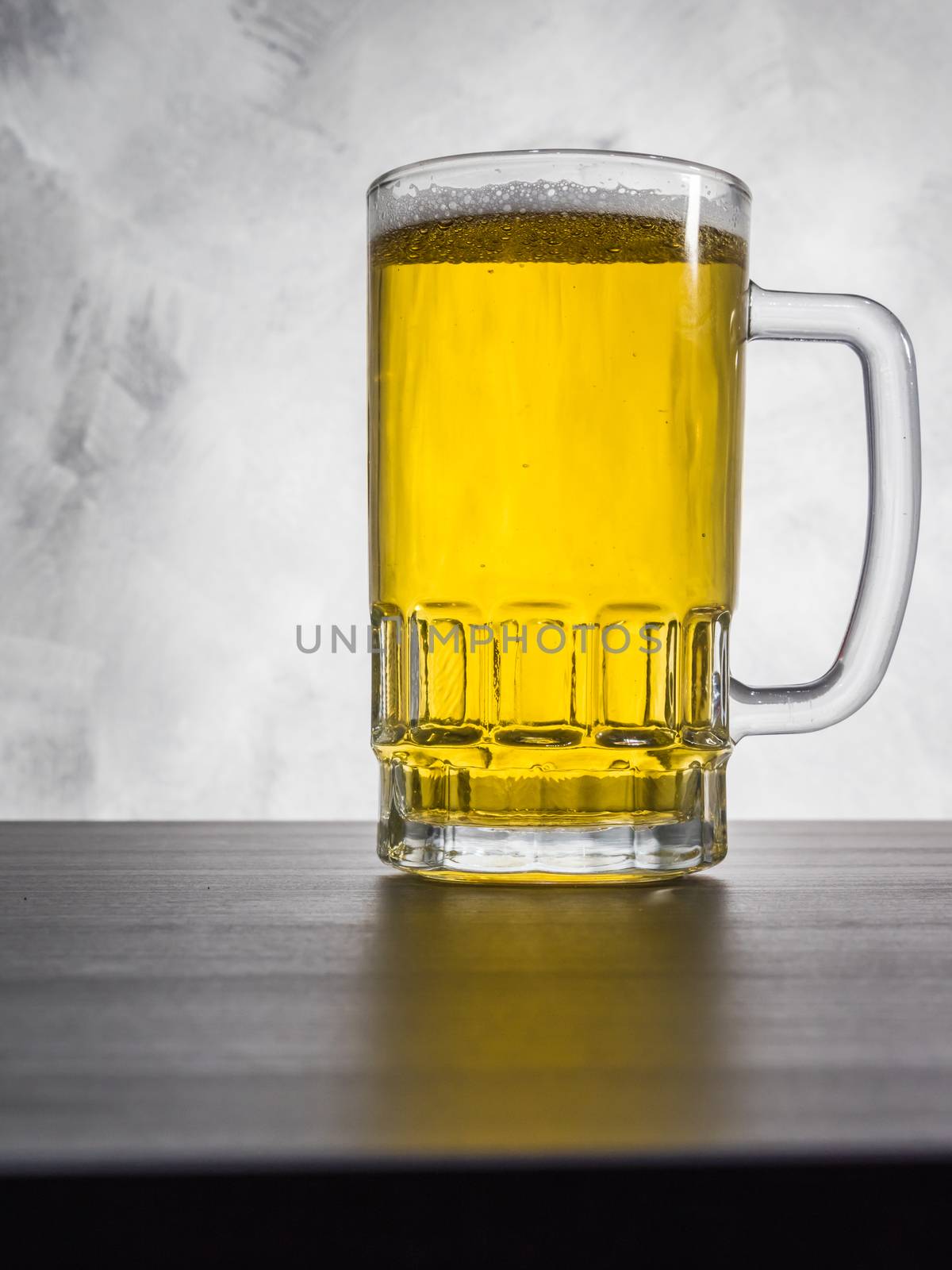 Glass of beer on a grunge background. by ronnarong