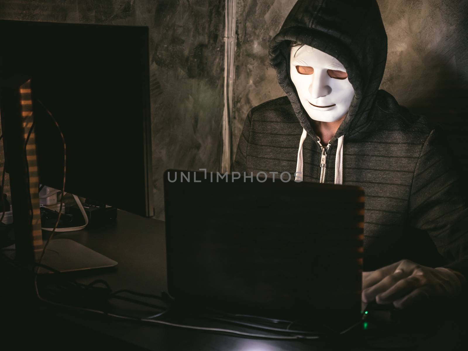 Computer hacker - Man in hoodie shirt with mask stealing data from laptop