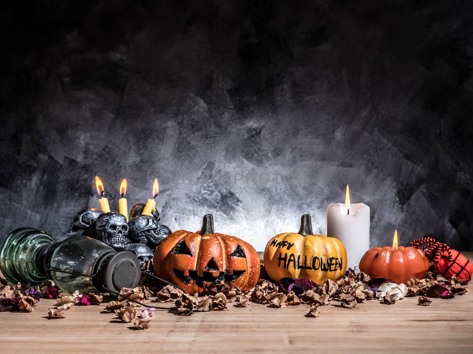 Halloween pumpkins with candlelight and skulls on dark background.