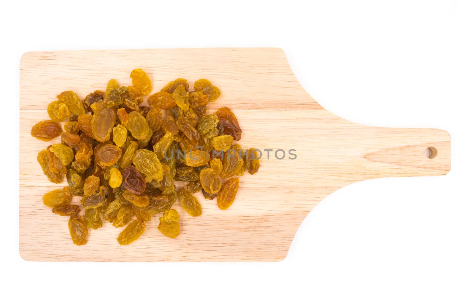 Yellow raisins on wooden tray.