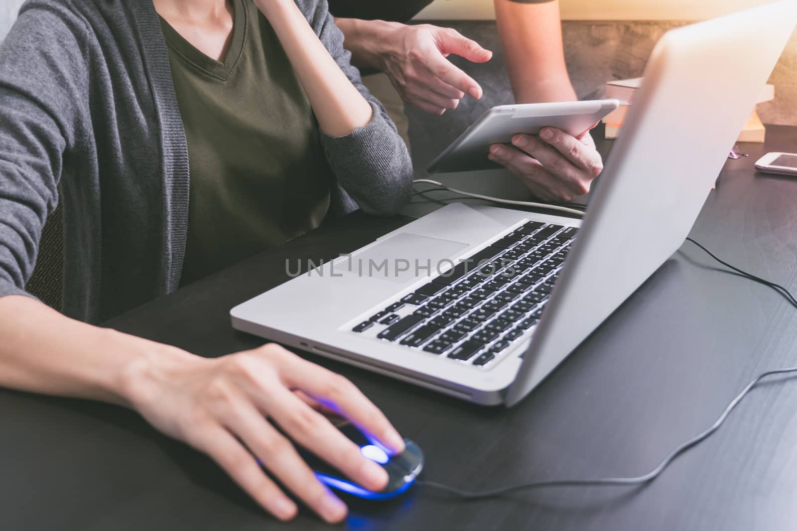 Business partners working together at office desk, they are using a laptop and tablet.