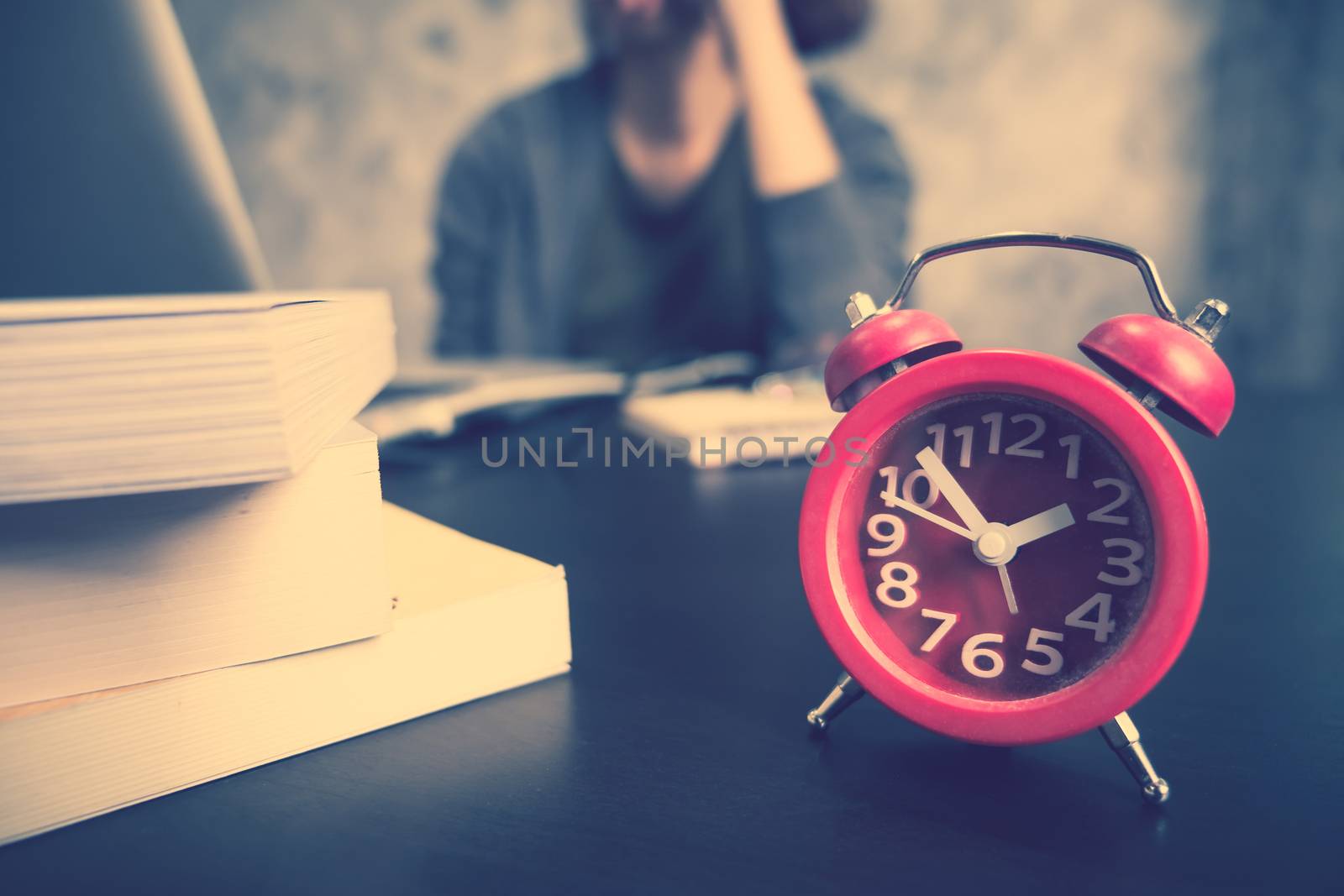 Close up of red clock on the desk, Afternoon time, Casual young woman using a laptop, Vintage tone