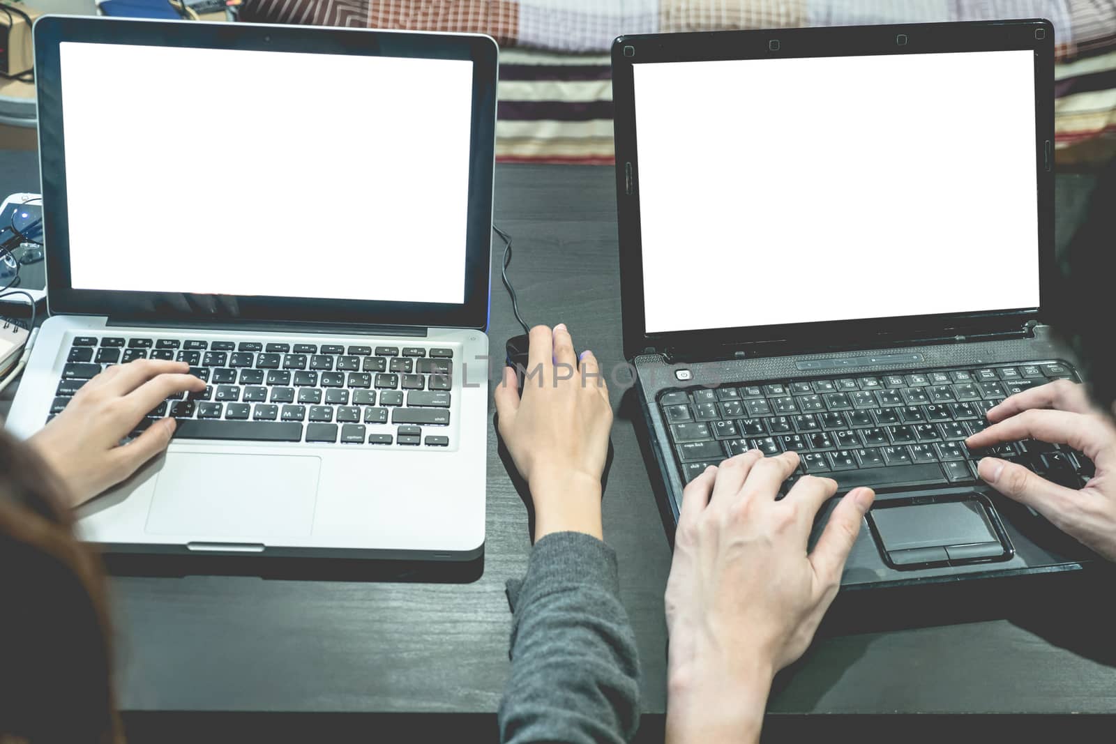 Business partners working together on the same desk, they are using a laptop with blank screen, Start up business concept