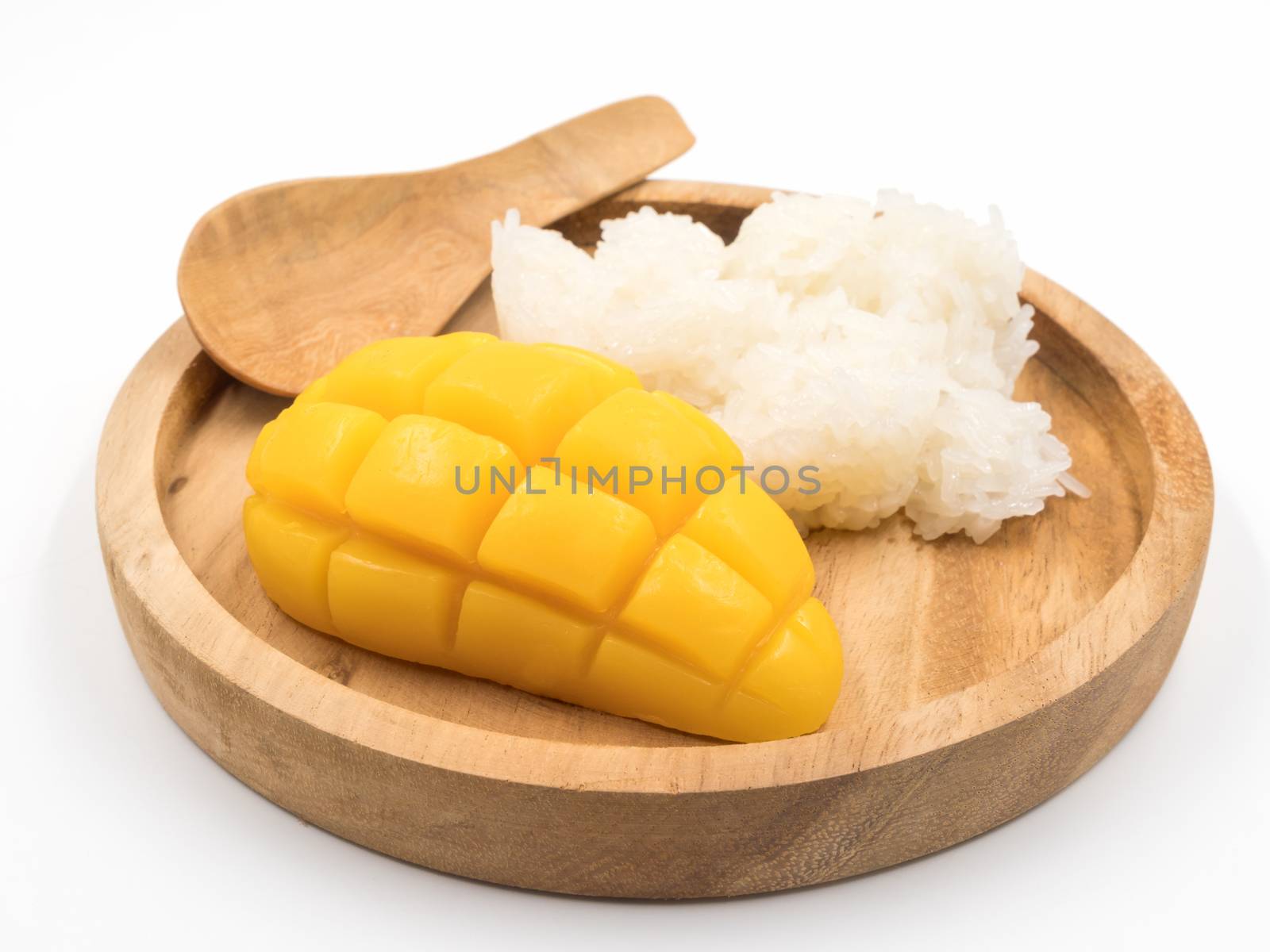 Ripe mango with sticky rice on wooden tray.