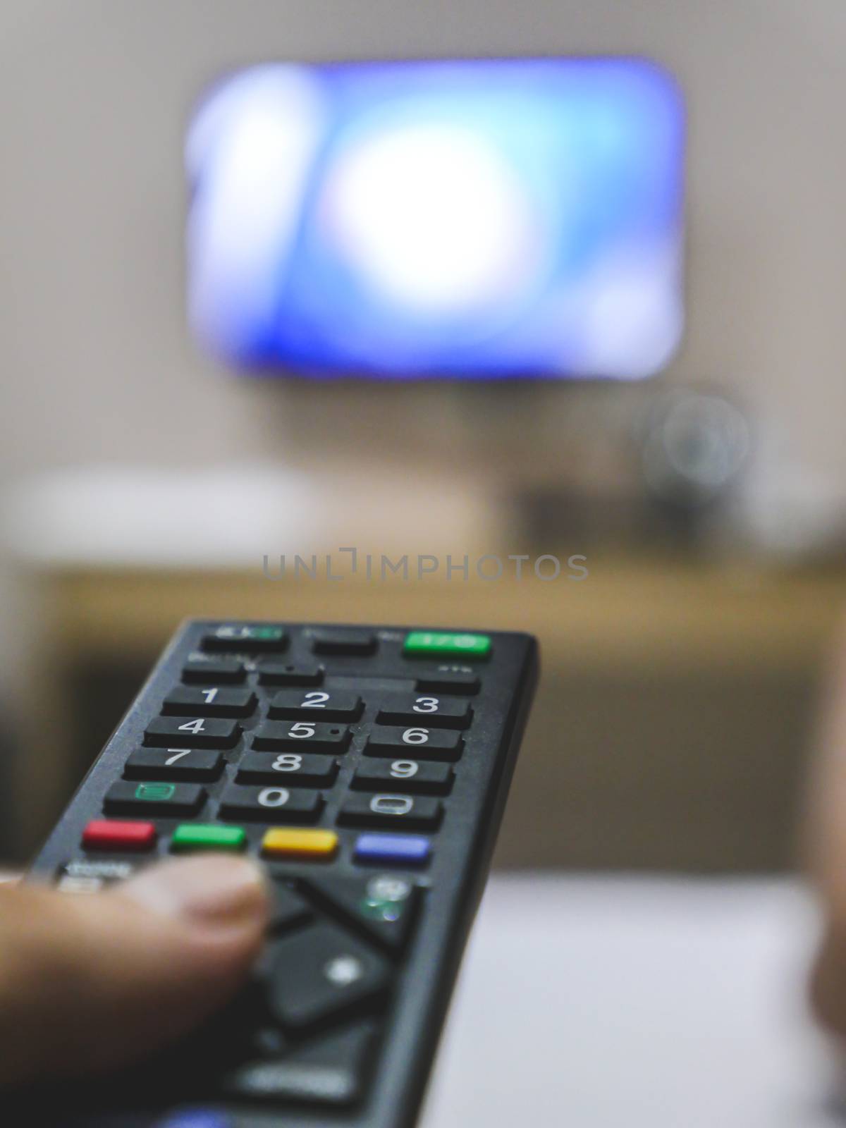 Television remote control in hand. by ronnarong