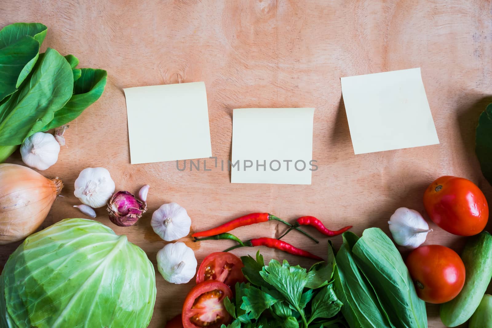 Top view of Fresh vegetables with Blank papers on wooden table background.