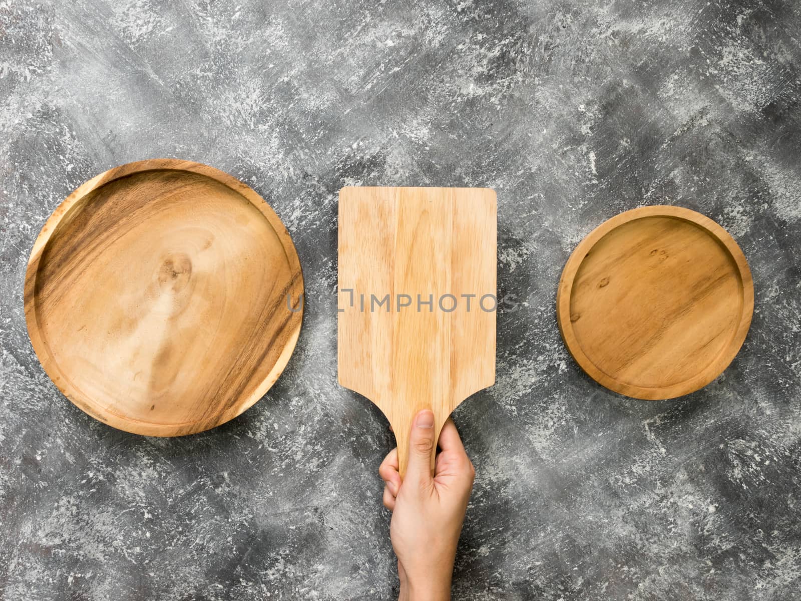 Top view of empty wooden tray with hand on grunge  background.