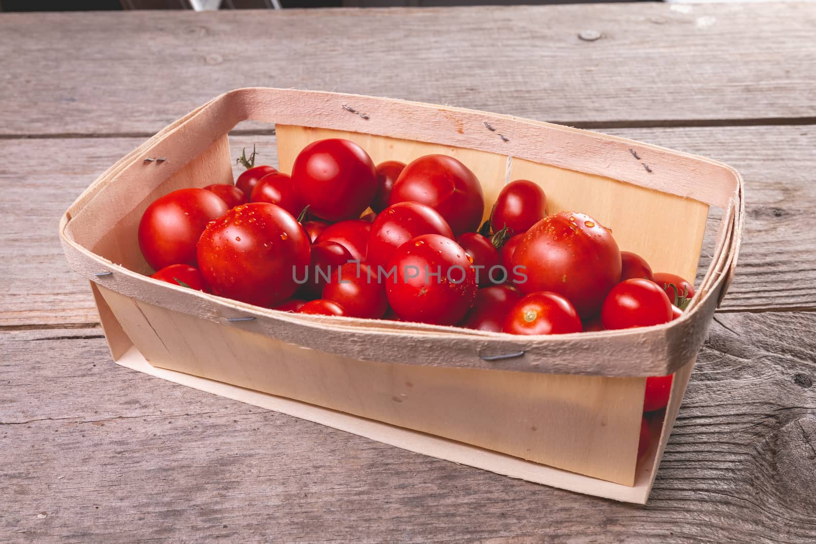 ripe tomatoes in a small wooden crate by AtlanticEUROSTOXX