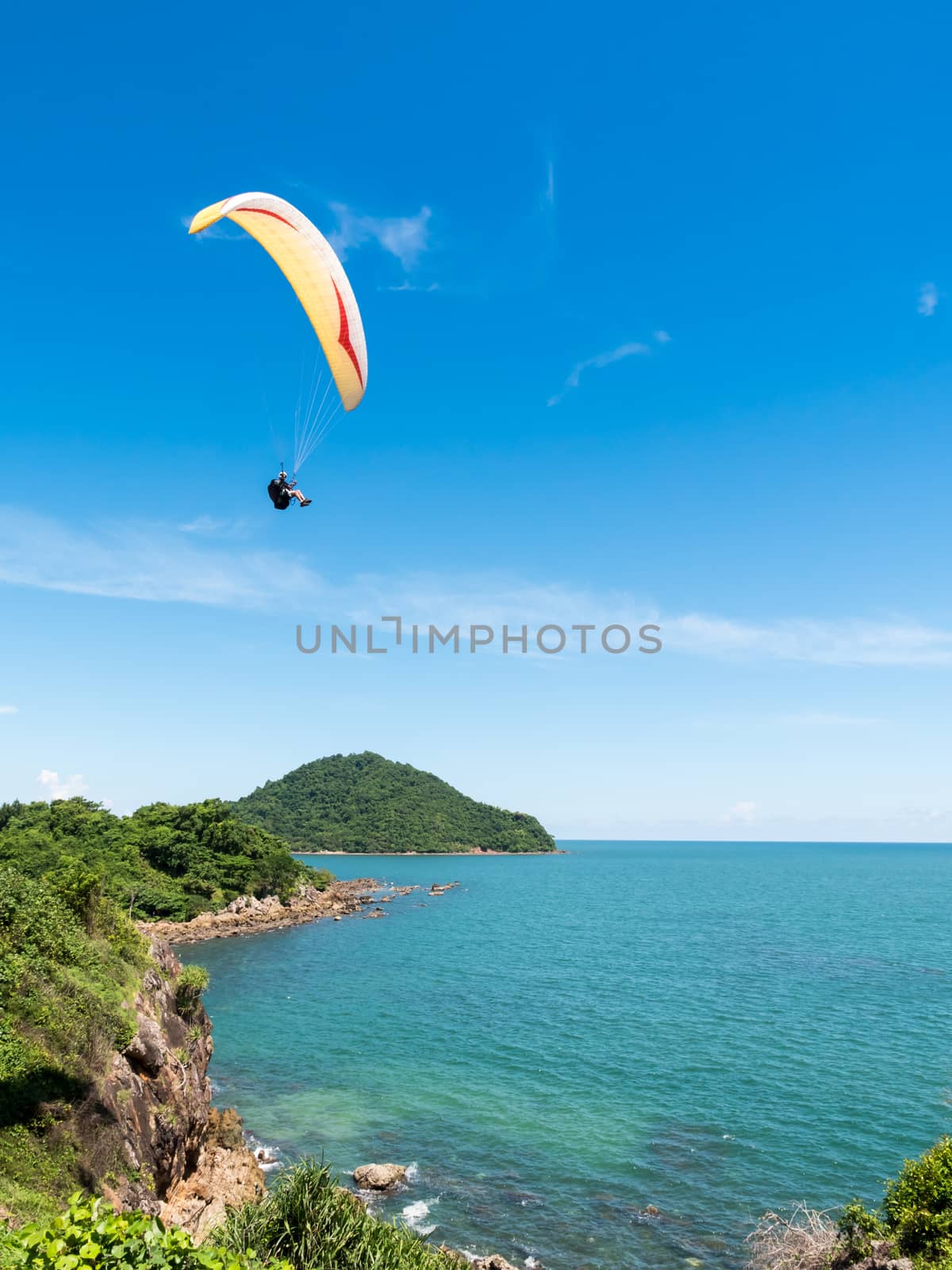 Beautiful seascape with Paraglider flying in blue sky.
