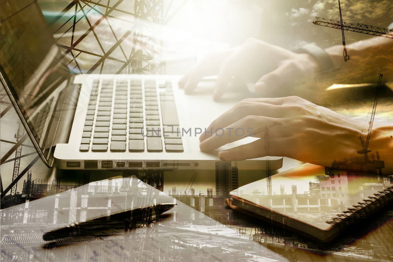 Double exposed of male hands working on laptop with the building construction site.