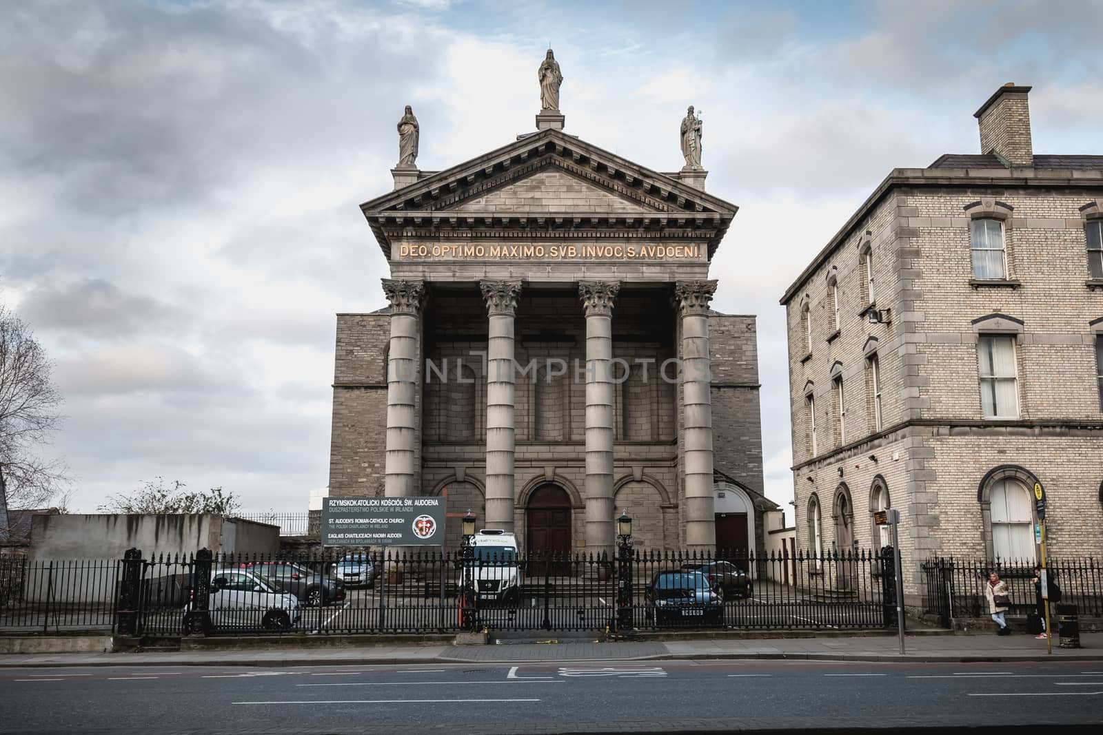 Dublin, Ireland - February 13, 2019: Street atmosphere and architecture of St. Audoen's Roman Catholic Church that people visit on a winter day