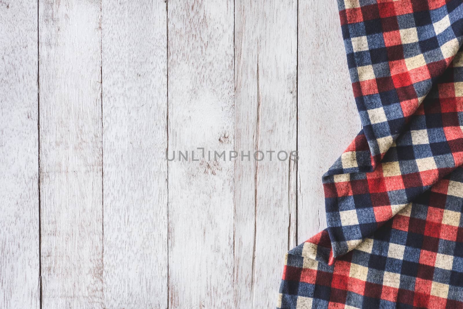 Top view of checkered cloth on wooden table background, Free space for text