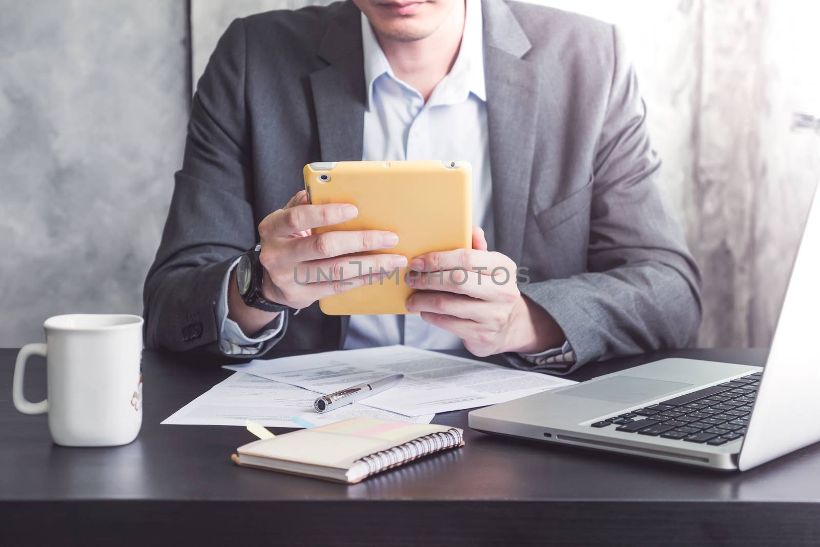 Close up of Businessman using Tablet on the office desk.