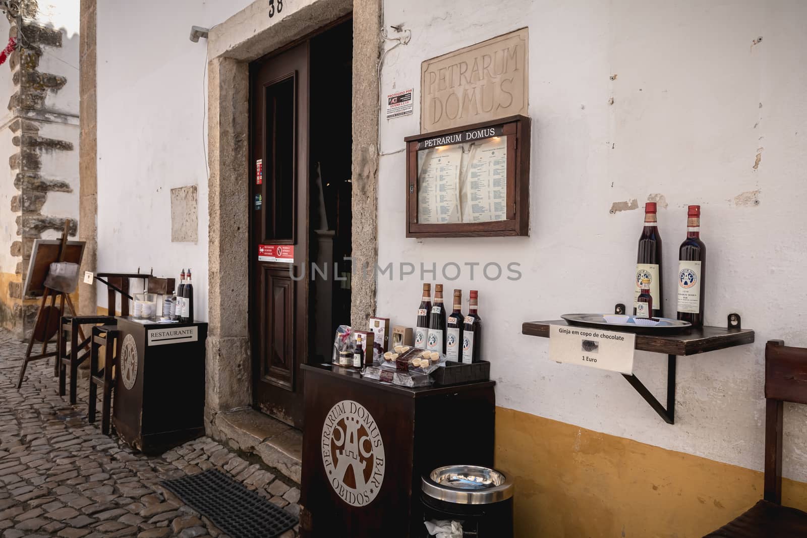 Obidos, Portugal - April 12, 2019: Display of a shop specializing in the sale of ginjinha or ginja, traditional cherry-based liqueur in the historic city center on a spring day