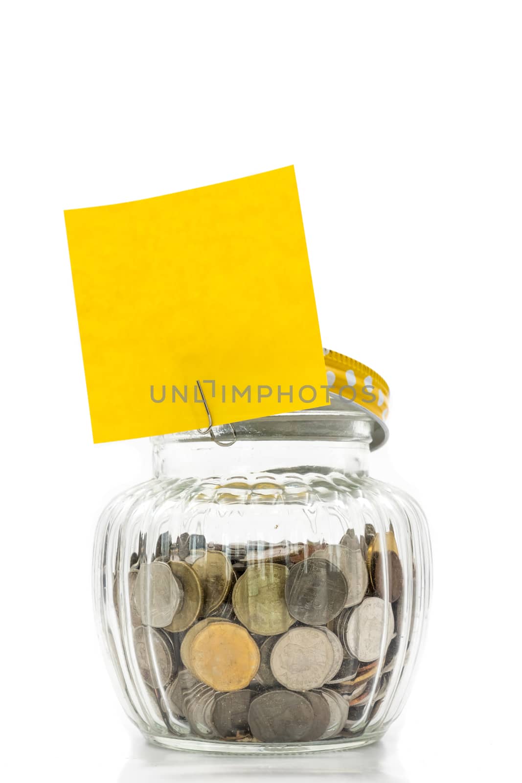 Coins in glass bottle with blank paper for text on white background, future saving concept
