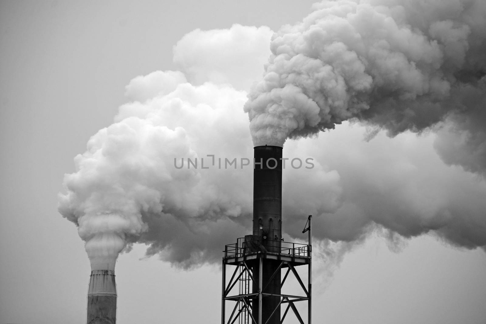 Two factory smoke stacks in black and white