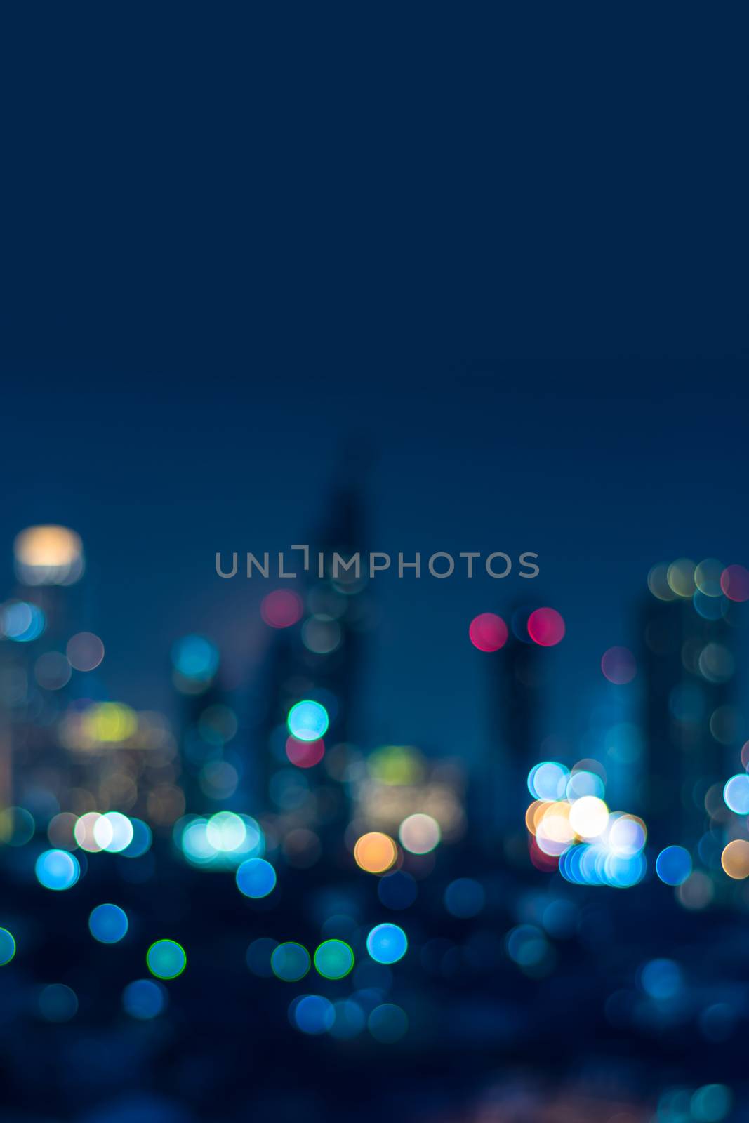 Vertical cover of blurred bokeh cityscape at twilight time, city background, aerial view angle from rooftop ob building, defocused city in downtown,graphic design for web online or book vertical cover