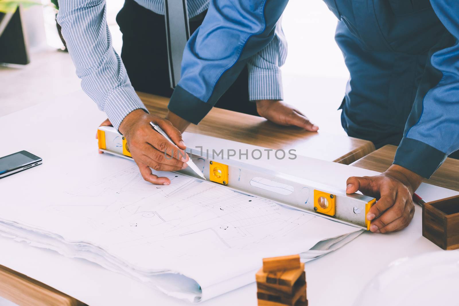 Team of engineers discussing architecture plan sketch at the construction site.