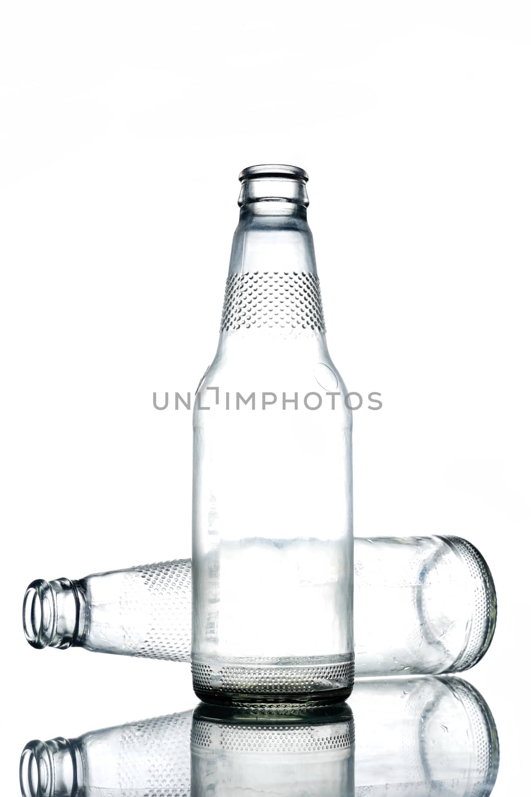 Empty colorless glass bottles on a white background.