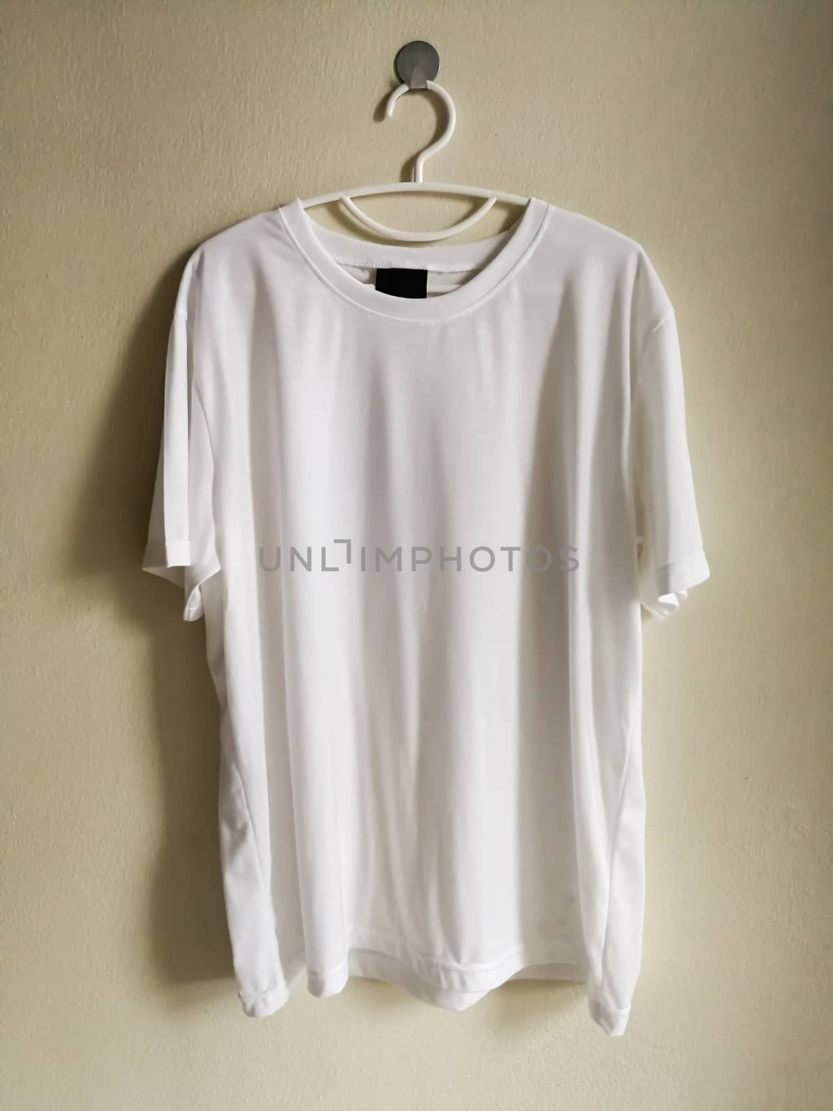 Blank t-shirt hanging on wall.