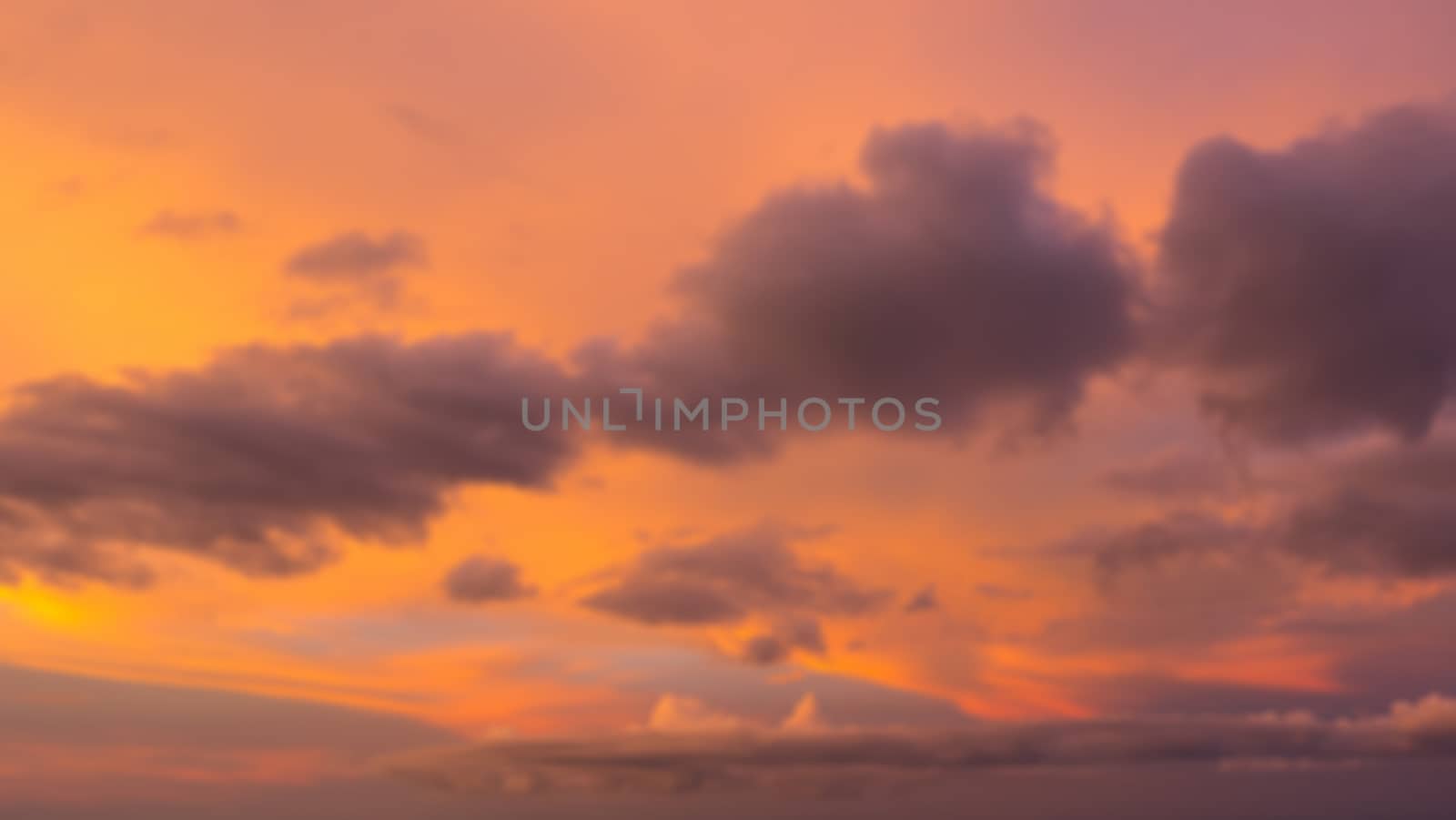 Dramatic sunset sky with clouds. Blur or defocus image.