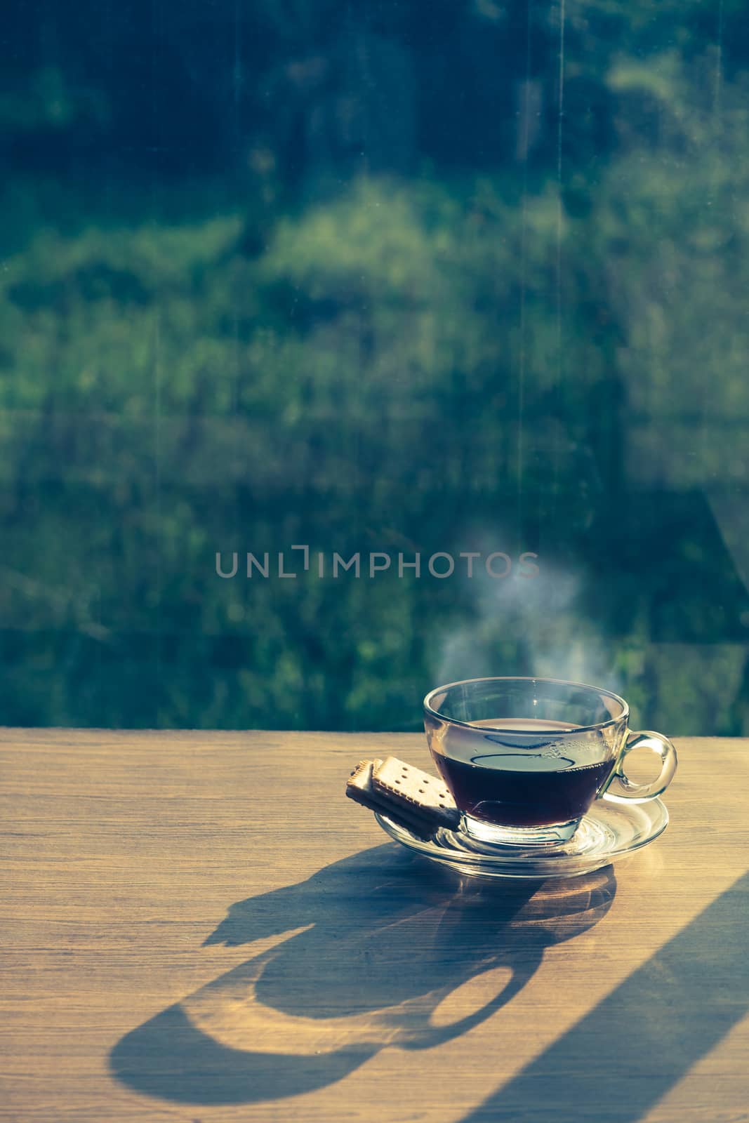 Cup of coffee on the table inside the window, coffee break in the morning with sunlight, relaxing and refreshing concepts.