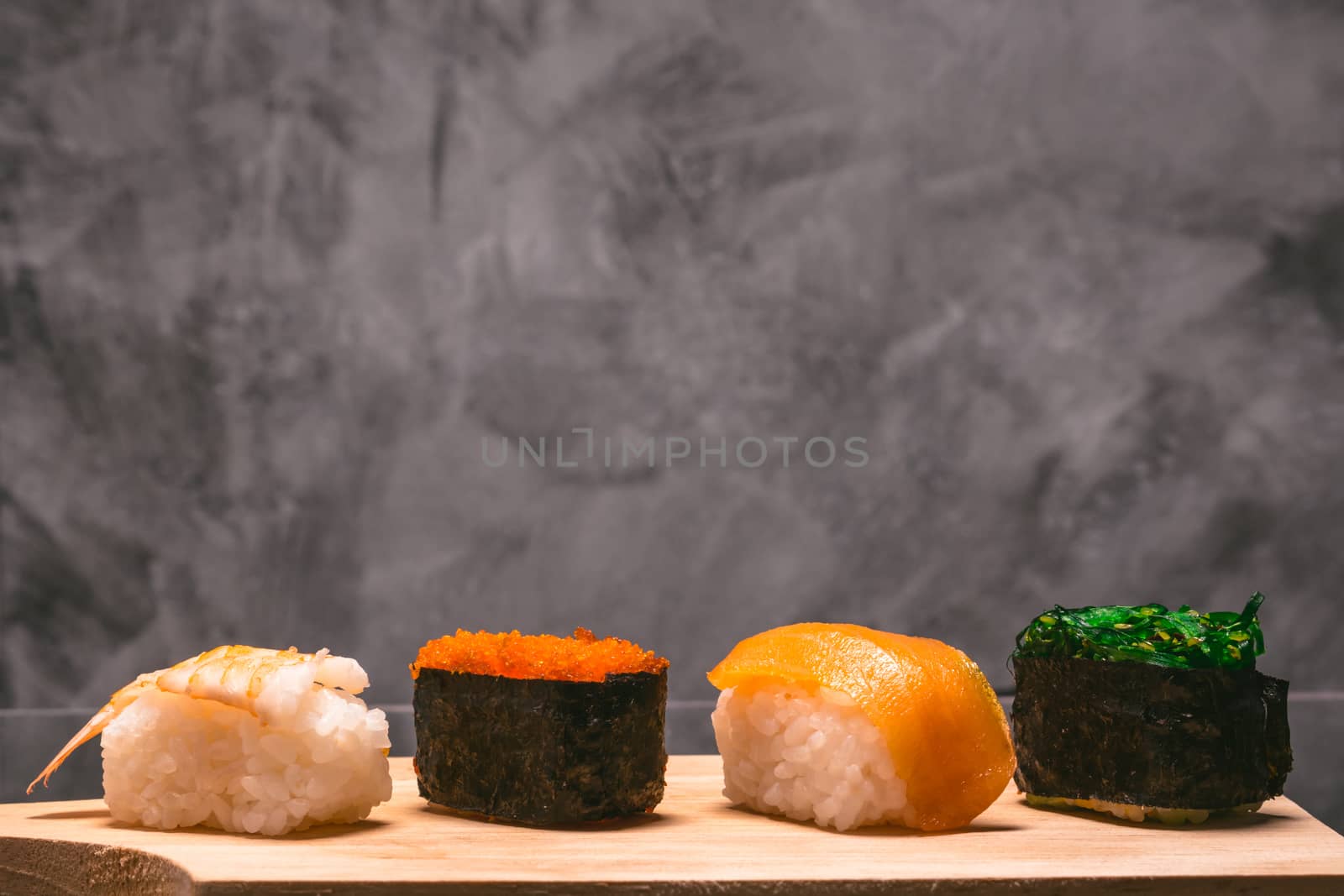 Sushi set on wooden plate on gray grunge background, Japanese food.