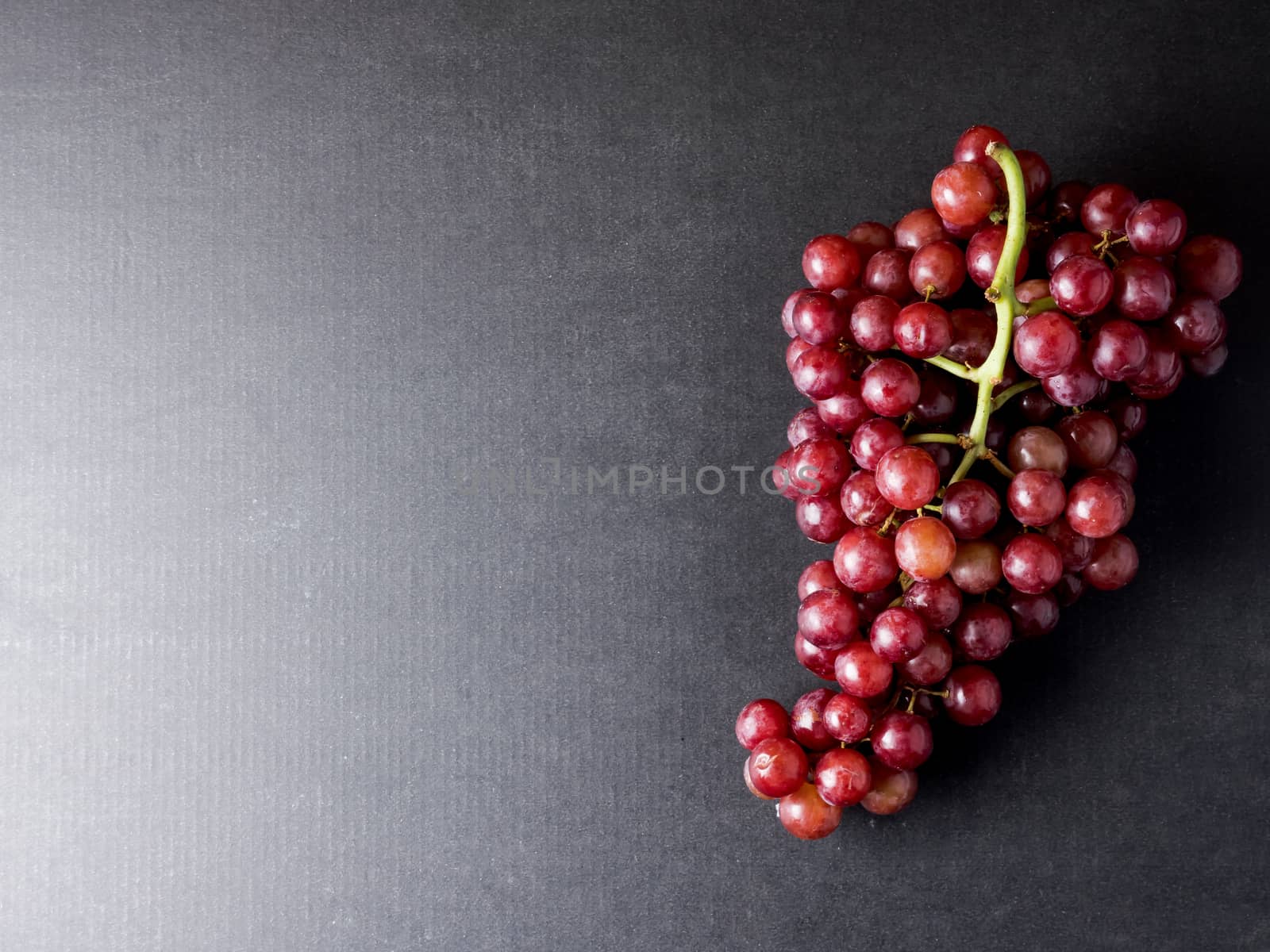 Top view of Red grapes on a black background. Free space for text