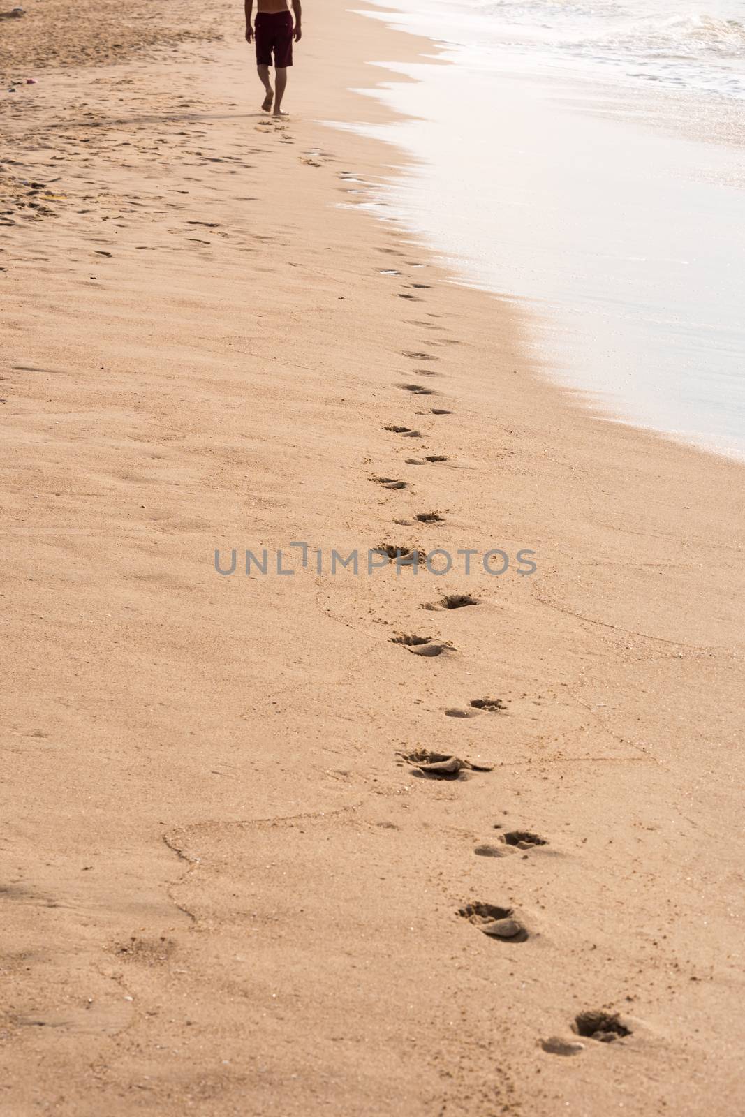 Footprints of a man walking on the beach. Travel concept by ronnarong