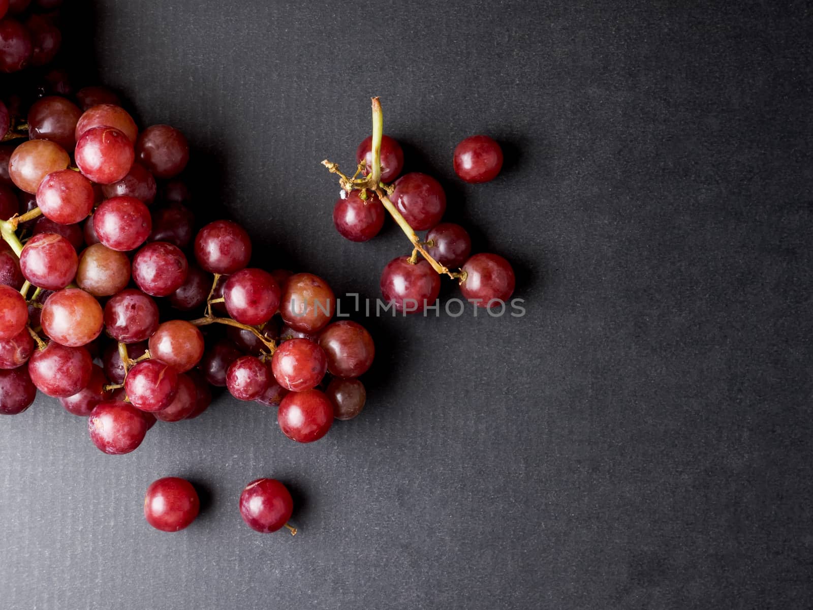 Top view of Red grapes on a black background. Free space for text