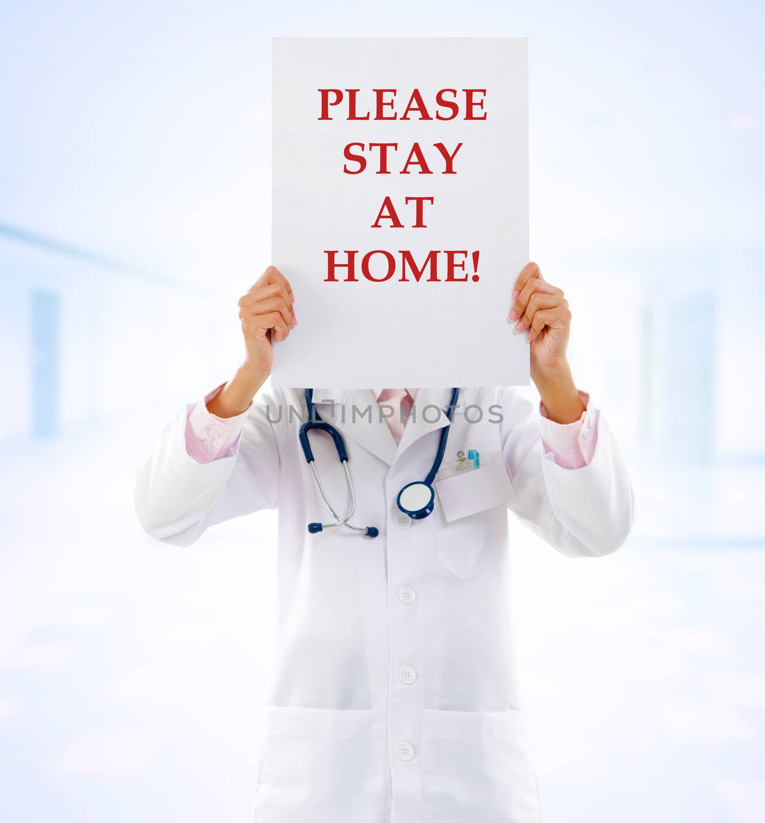 Medical staff holding a card with stay at home on it.