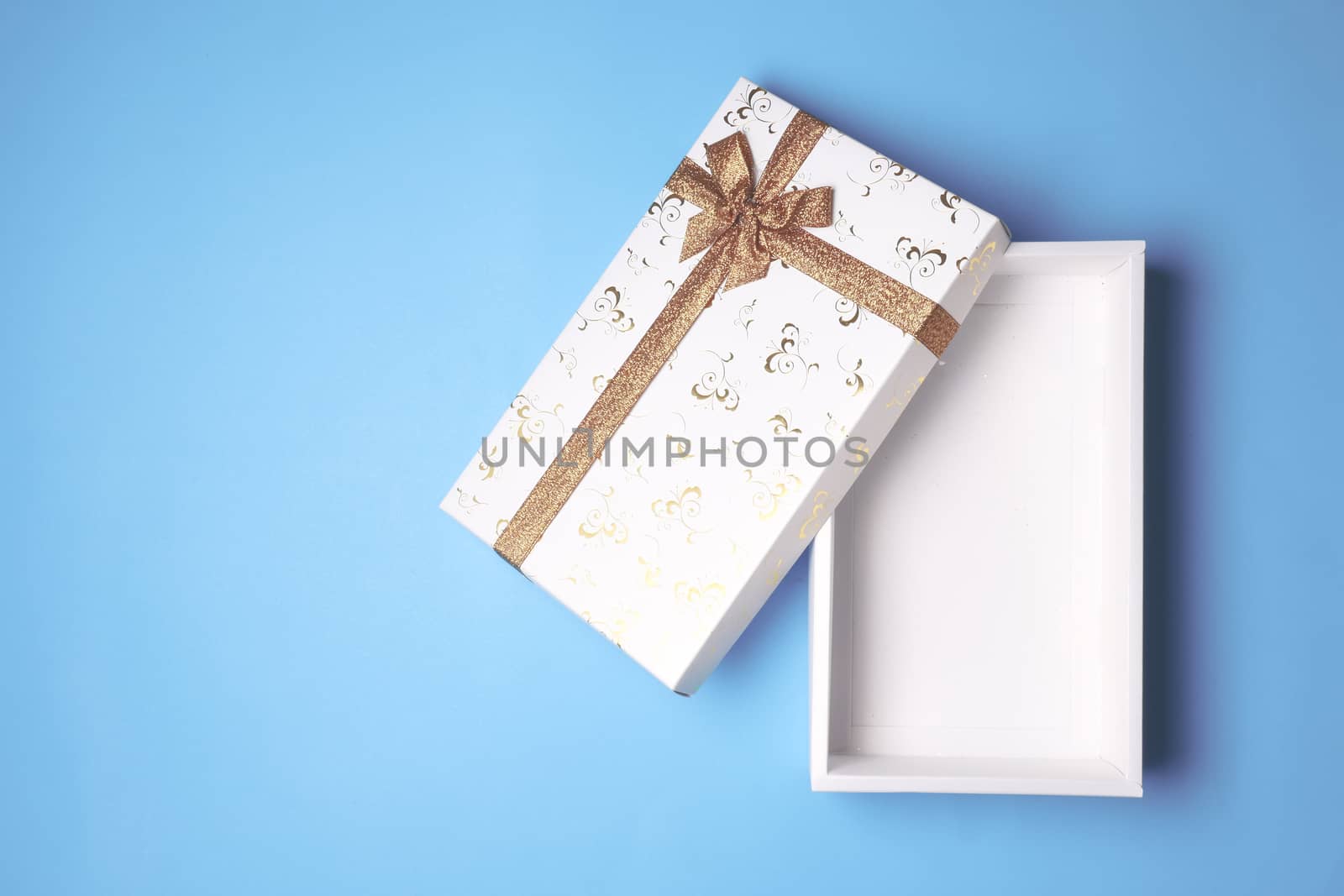 Top view of open white gift box on blue background. Free space for text