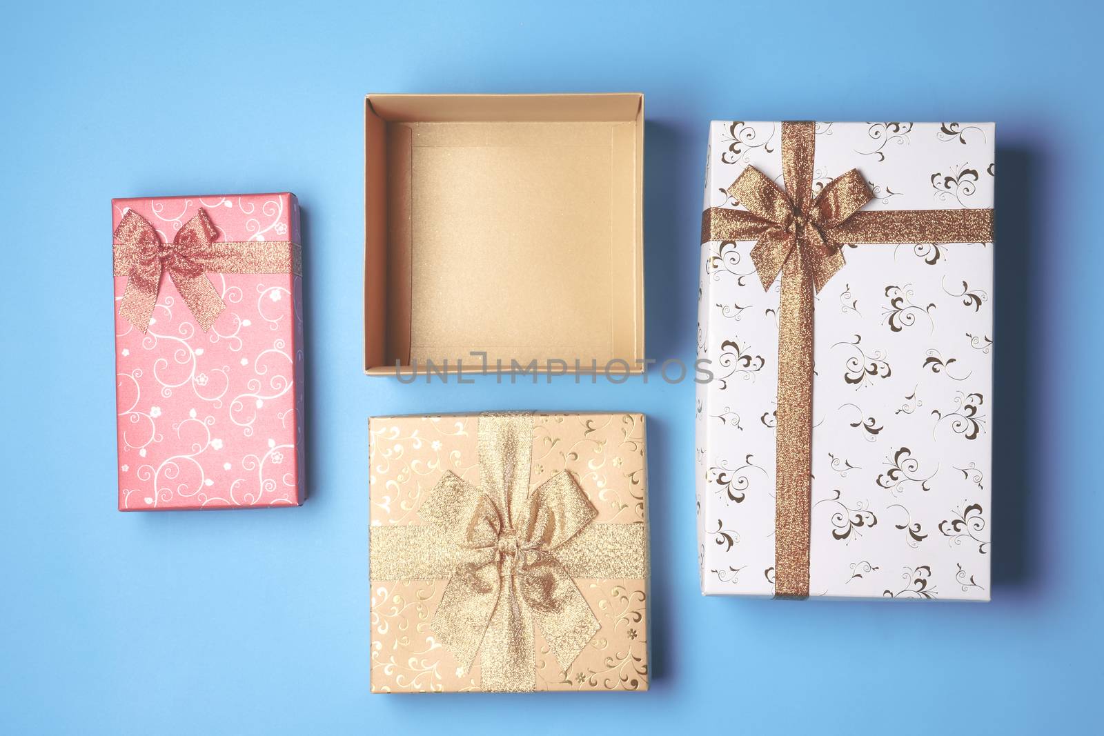 Top view of open gift box and presents on blue background.