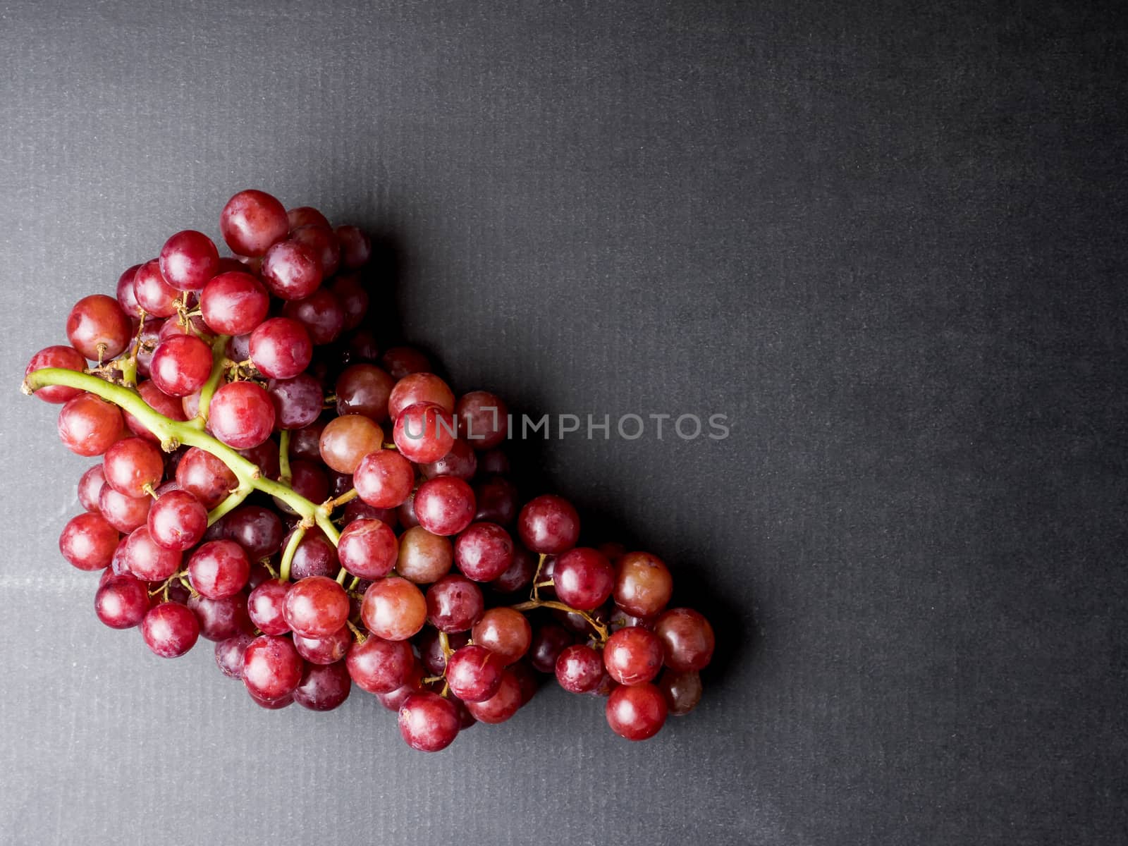 Top view of Red grapes on a black background. Free space for text