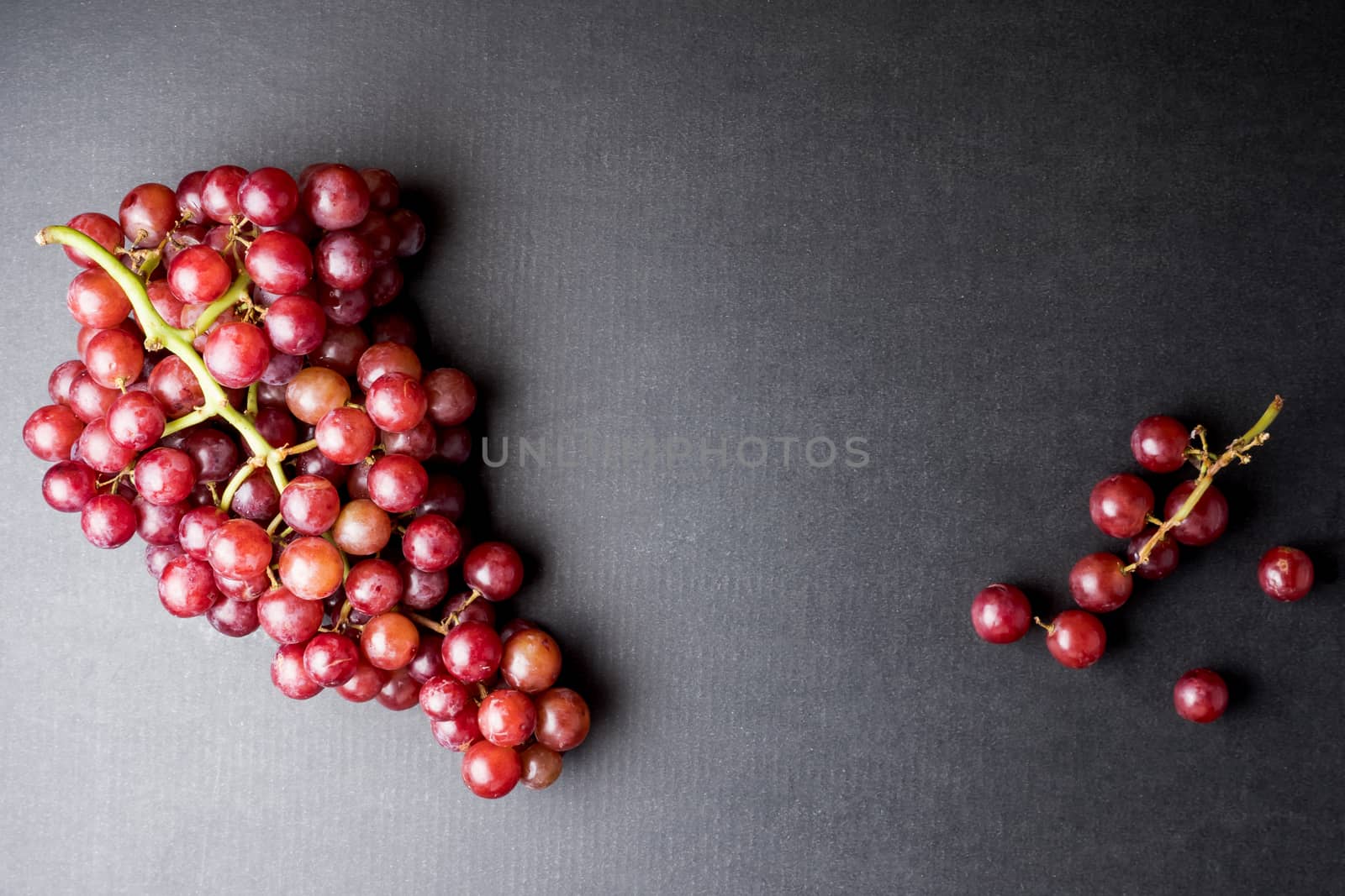 Top view of Red grapes on a black background. Free space for text