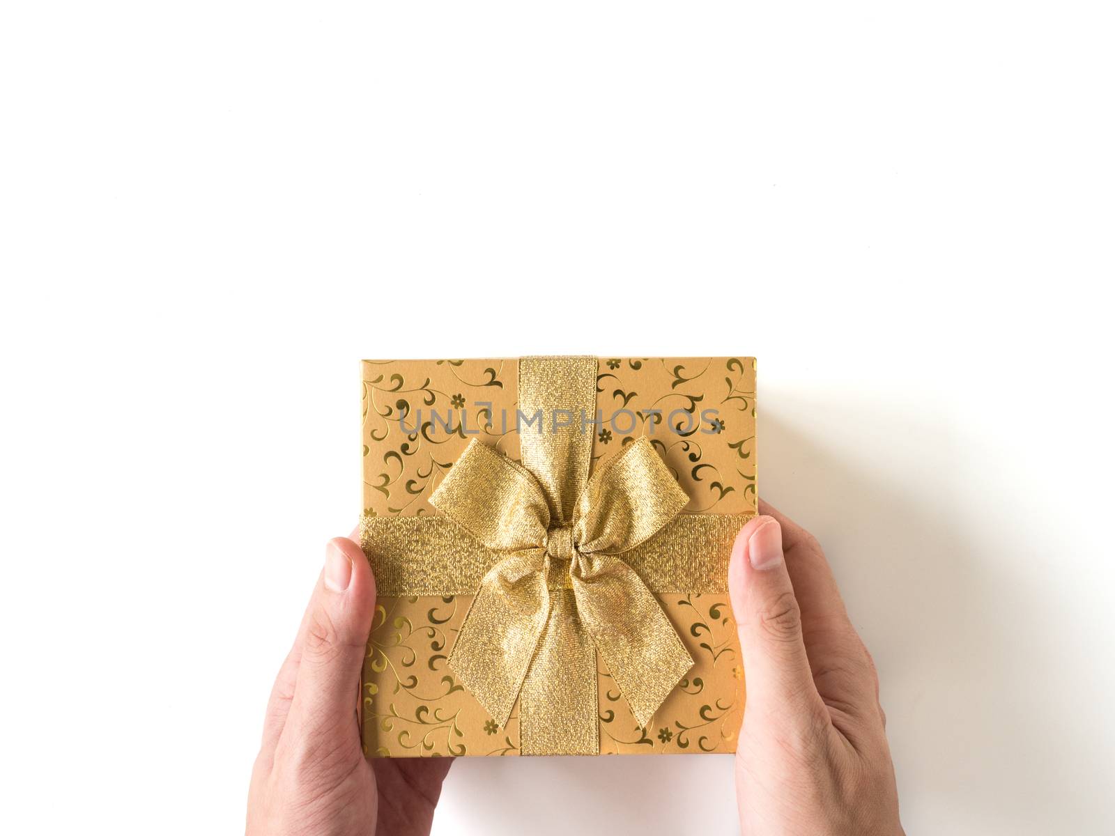 Top view of  hands holding a gift box on a white background.