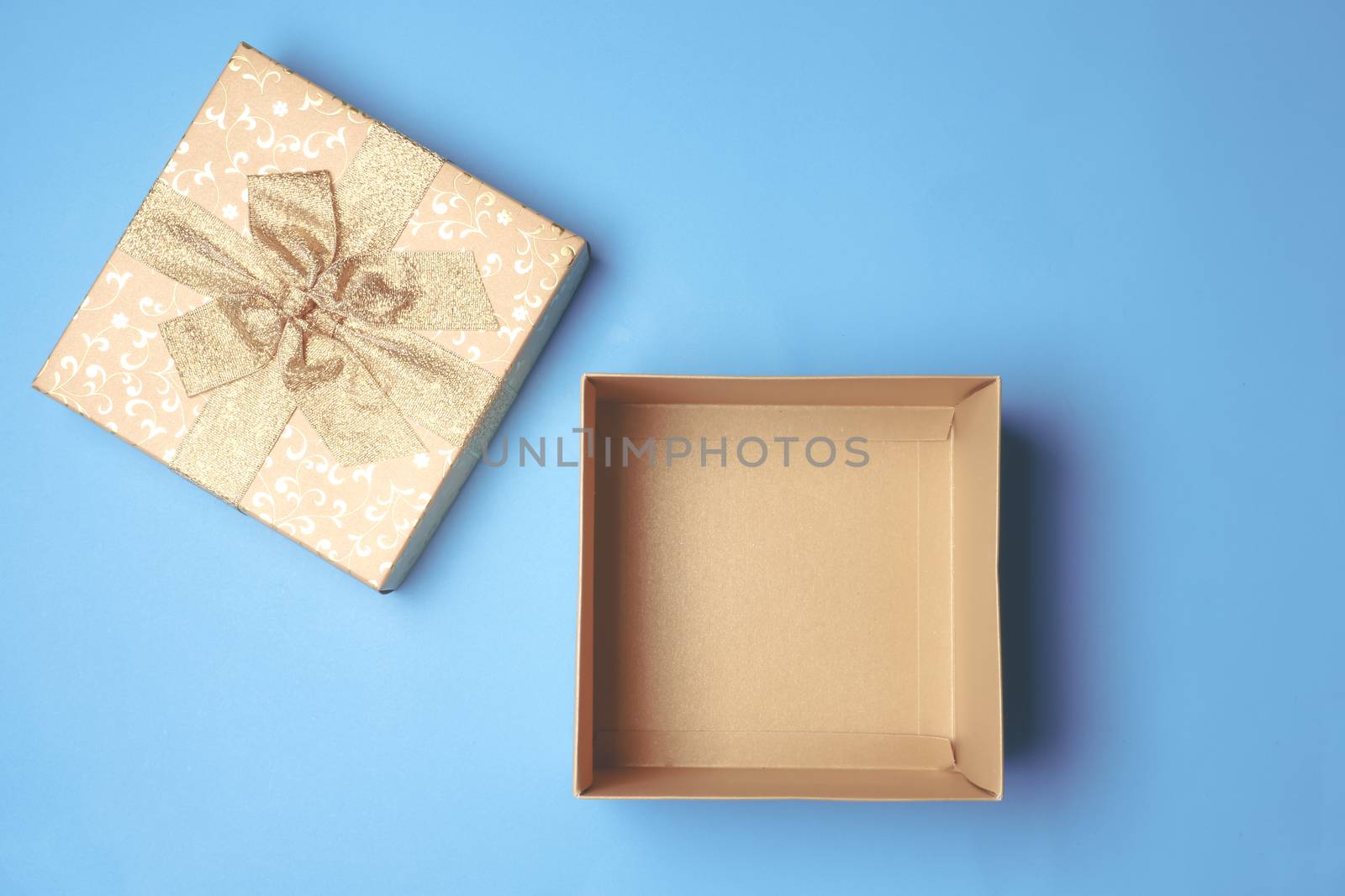 Top view of open gift box on blue background.