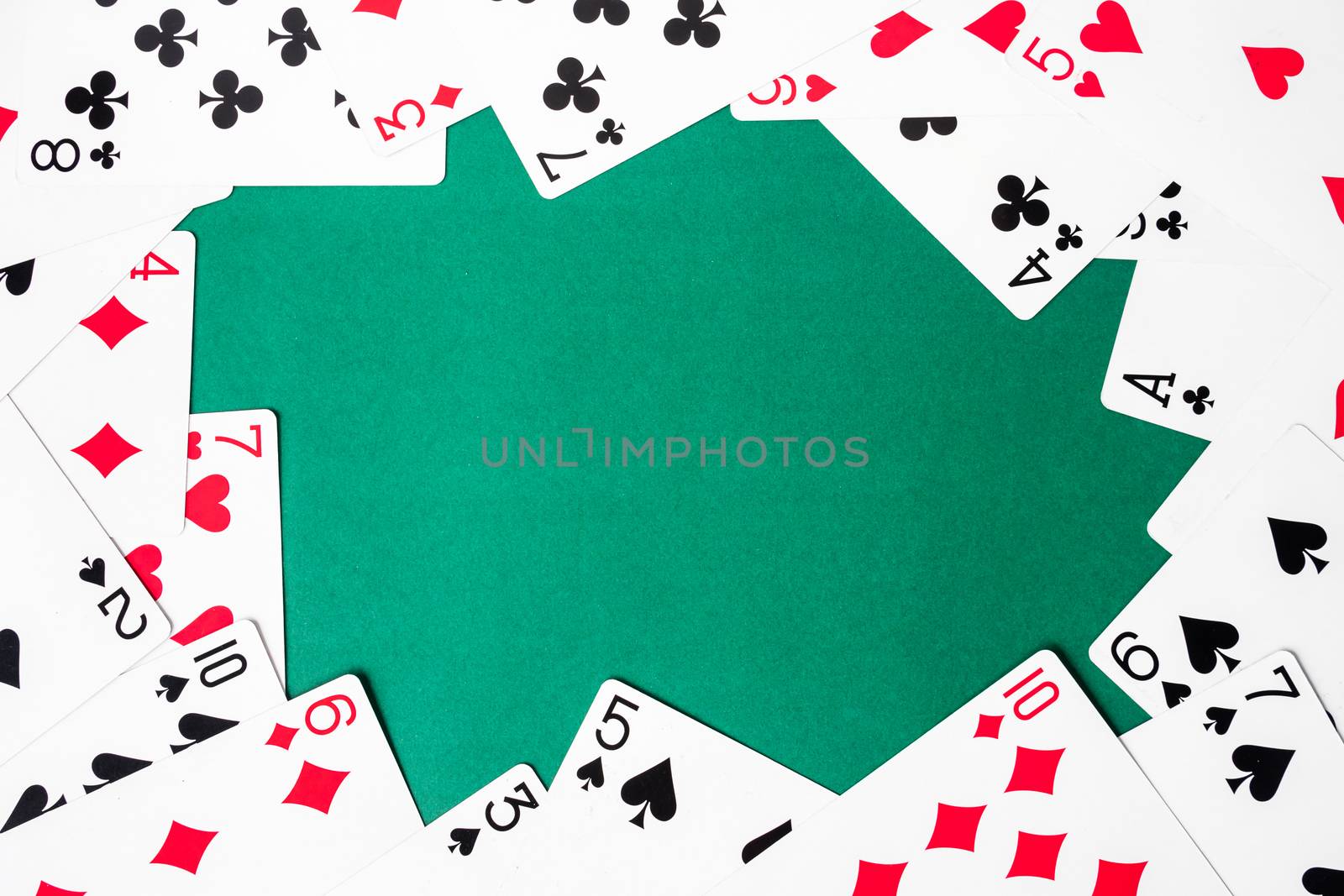 Playing cards on green background. Free space for text