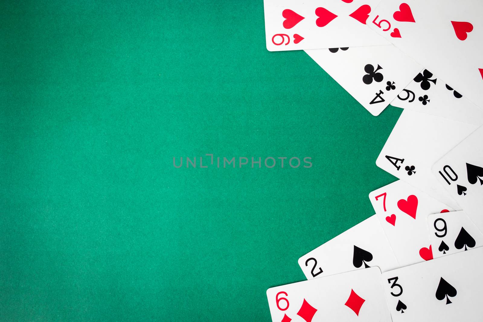 Playing cards on green background. Free space for text
