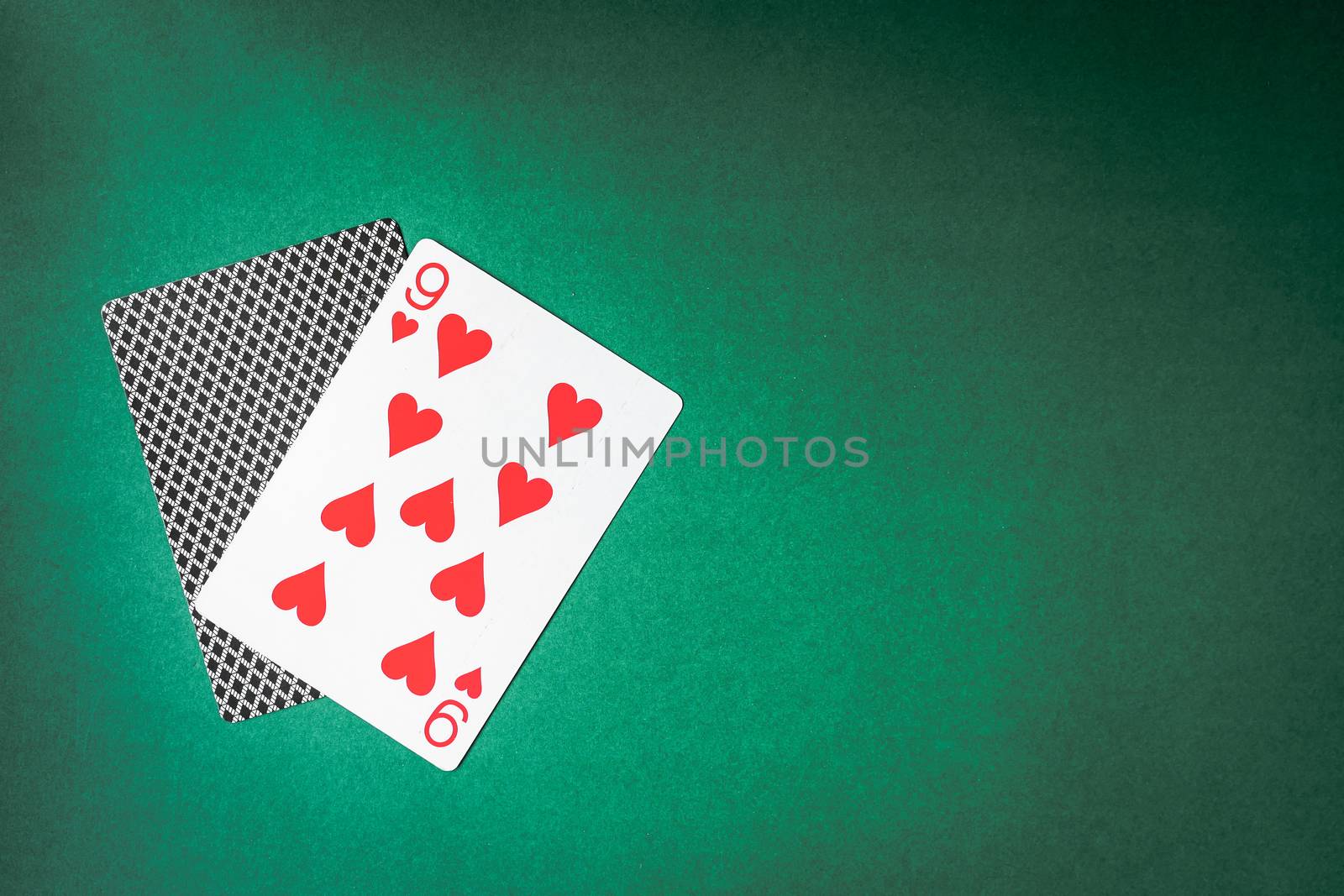 Playing card and back designs on green background. Free space for text
