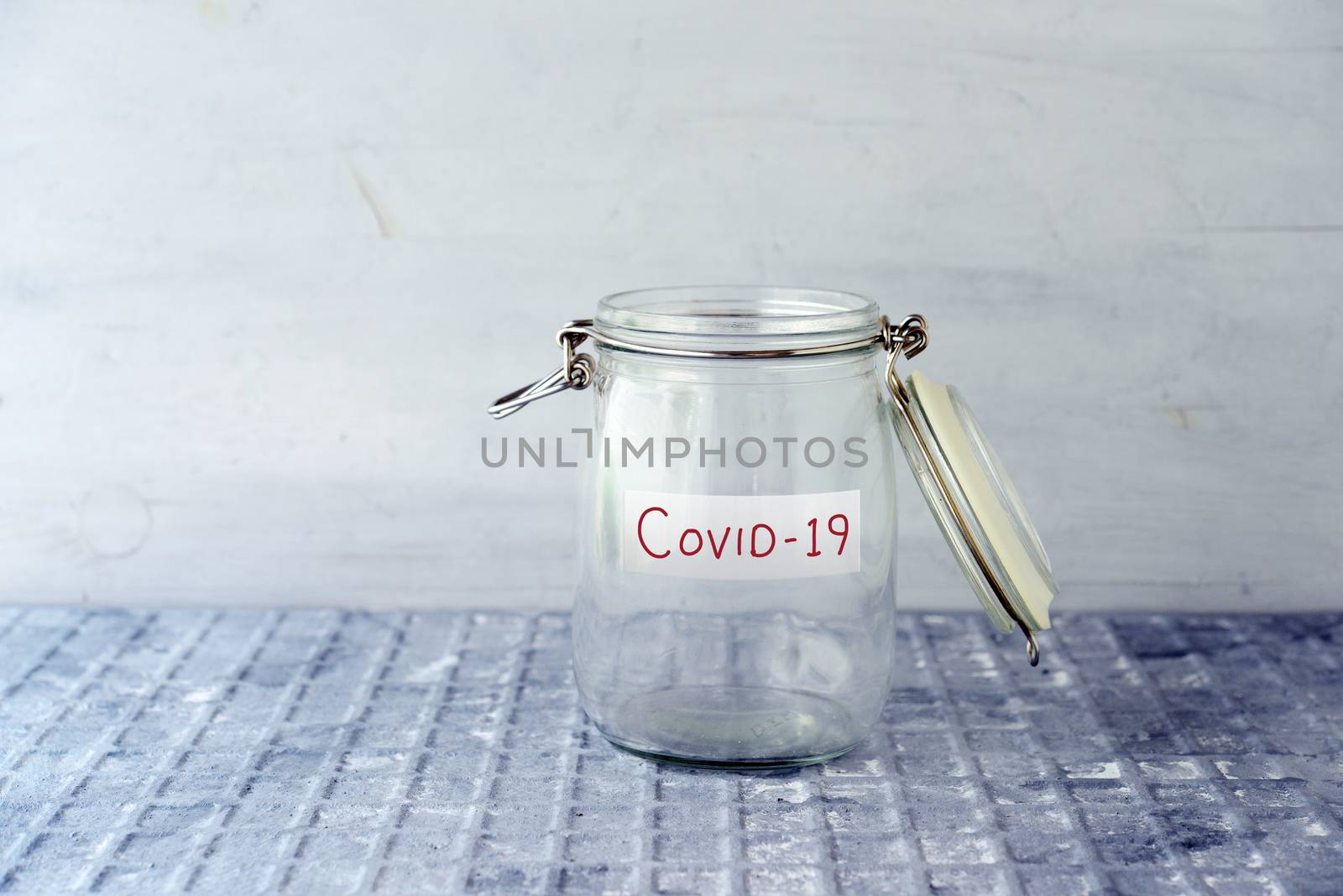 Empty glass money jar with covid19 label, financial concept.
