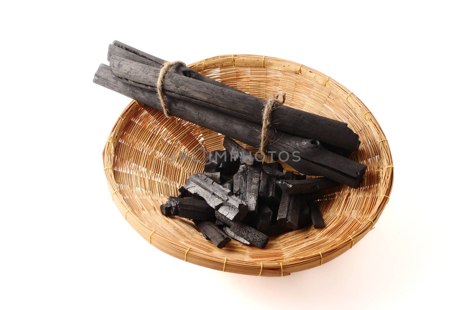 Charcoal in basket on white background.