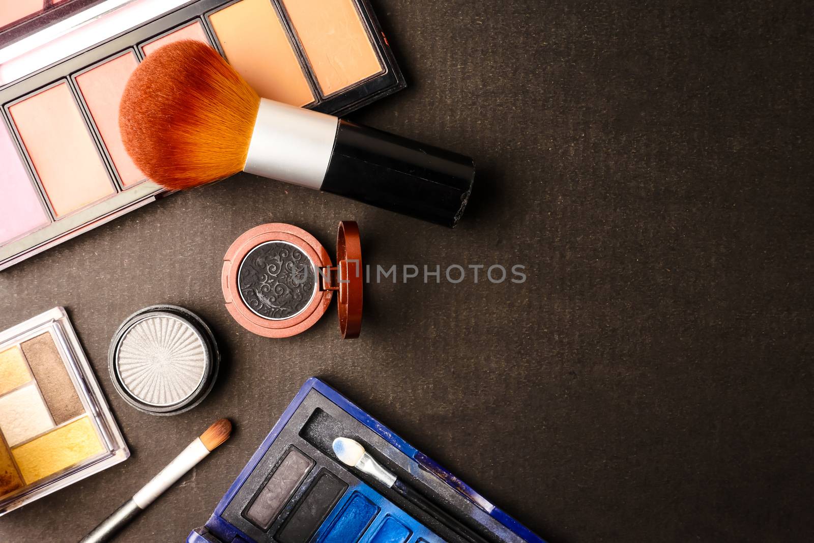 Top view of cosmetics set for makeup on a blue background. Free space for text.