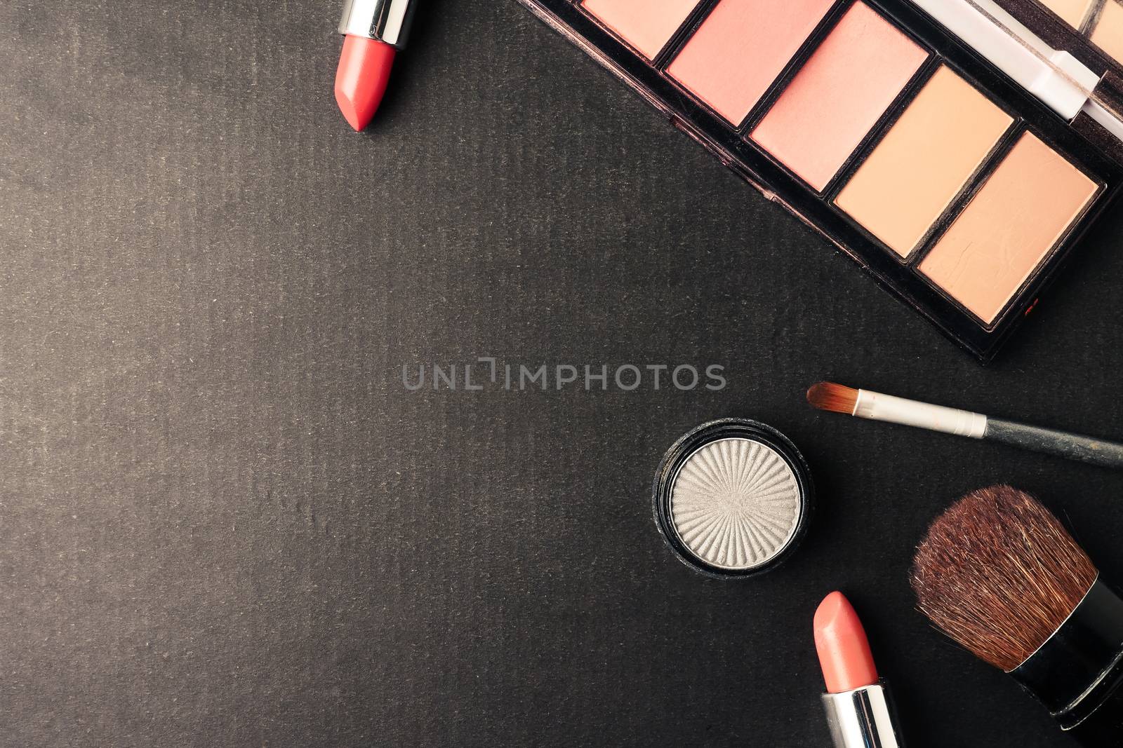 Top view of cosmetics set for makeup on a blue background. Free space for text.